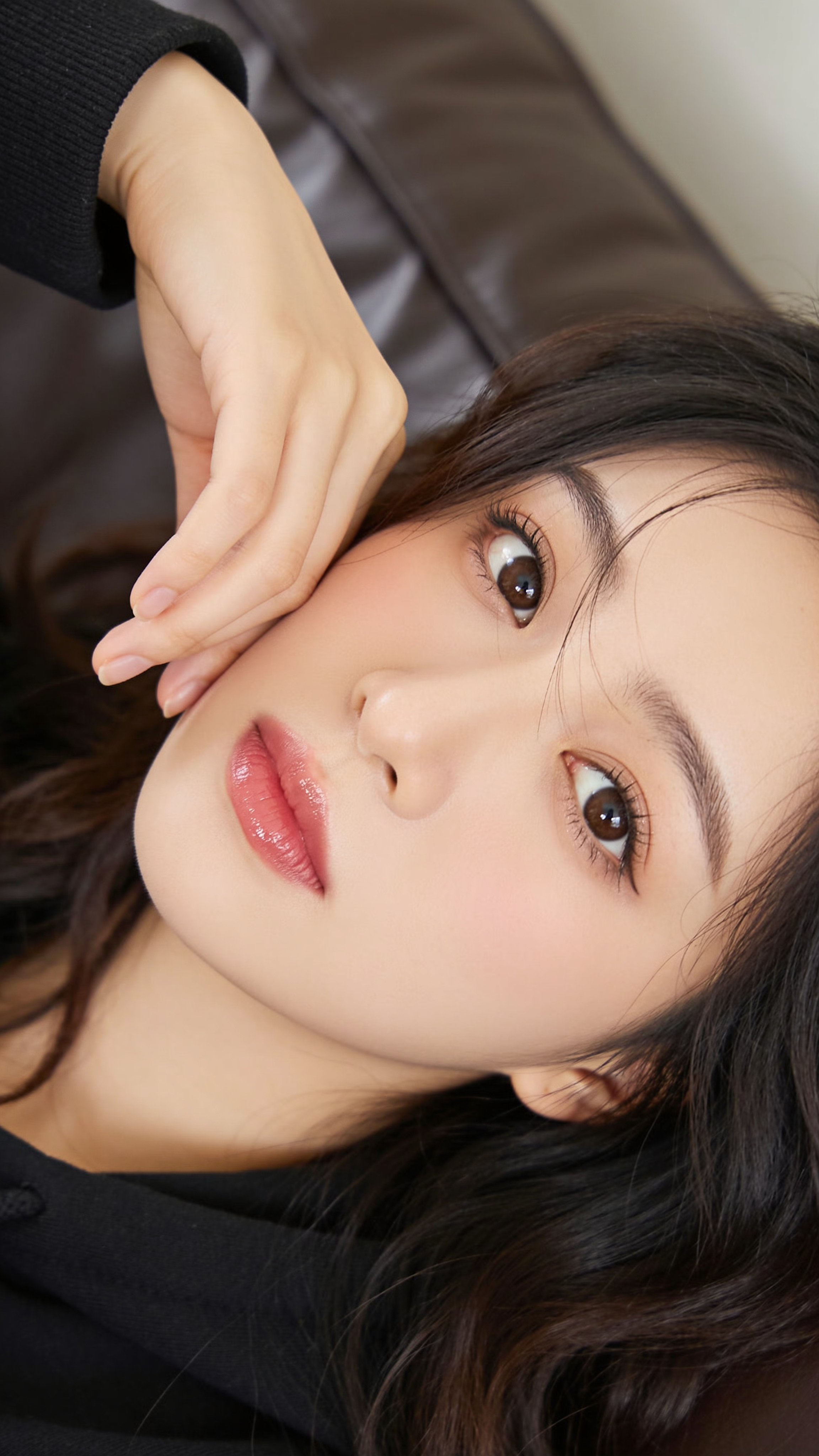 20대 초반의 젊은 동아시아 여성을 사실적으로 클로즈업한 초상화. 맑고 매끈한 피부, 섬세한 이목구비, 크고 표정이 풍부한 짙은 갈색 눈에 긴 속눈썹과 은은한 아이라이너, 부드럽게 — AI image prompt — Seedream 5